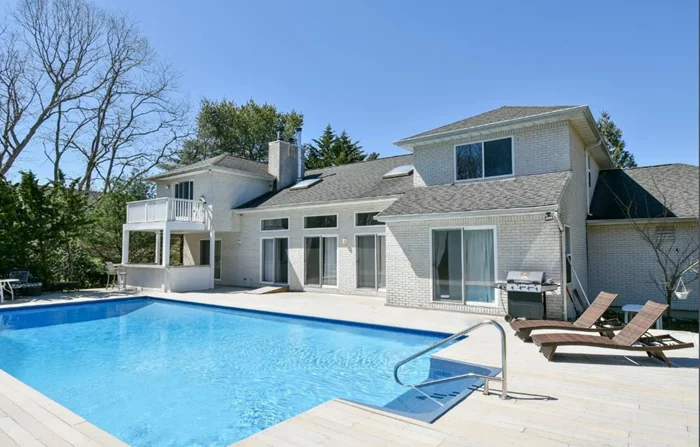 Enjoy a summer of endless splendor here at 24 Wisteria Drive in the town of Southampton! Conveniently located in the hamlet of Remsenburg with immediate access to every major highway and minutes away from West Hampton Beach.Inside this stunning Post Modern beauty you are greeted with an open concept floor plan, vaulted 30-foot ceilings with balcony, bridge and lookout, totaling over 4400 sqft of fine East End living. Enjoy direct access from the grand living room to the kitchen and 20x40 salt water in-ground pool. The pool is surrounded by a gleaming treks deck expanded to accommodate a BRAND NEW 6-person salt water jacuzzi. Views of private woods and calming nature adorn this 1 acre+ property and its beautifully manicured flowerbeds. Ample parking for up to a dozen cars is even more convenient with this home&rsquo;s circular, wraparound driveway. 2-car attached garage, outside wet bar with refrigerator and tennis court complete the luxurious lifestyle of a summer in the Hamptons.