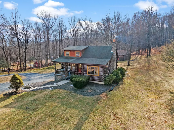 TOWN OF CRAWFORD LOG HOME SITUATED ON 25+ ACRES OF SERENE WOODED LAND. This charming 3-bedroom, 2-bathroom log home is situated in the Town of Crawford, within the Pine Bush School District. Conveniently located just 10-15 minutes from local restaurants, shopping centers, and essential services such as banking and postal facilities, this home offers both comfort and accessibility. Surrounded by nature, it is near several parks, including the Crawford Walking Trail and Winding Hills County Park. Major highways, including Route 17K, Route 302, and Interstate 84, provide easy access to Orange County Airport and Stewart International Airport, making travel and commuting effortless. The location is just the start check out the amenities this home has to offer starting with the kitchen combining classic craftsmanship with contemporary convenience. Deep green cabinetry with black iron hardware is complemented by butcher block style countertops, offering both style and function. A farmhouse sink sits beneath a row of large windows, allowing natural light to fill the space while providing a view of the surrounding trees. Exposed log beams and wood-paneled ceilings add to the warm, rustic aesthetic, while stainless steel appliances integrate modern practicality. The open-concept living and dining areas highlight the homeâ€™s impressive architecture. Vaulted ceilings with exposed log rafters create an airy, spacious feel, while large windows frame the natural scenery. The dining space sits beneath a classic chandelier, while the adjacent living area is anchored by a floor-to-ceiling stone fireplace, complete with a wood-burning stove. The natural wood flooring enhances the seamless flow between spaces, emphasizing the homeâ€™s log cabin character. The main level bathroom features a modern-rustic blend of design elements, including a sleek vanity with matte black fixtures, a bold patterned tile floor, and a tiled shower with classic subway tile detailing. Upstairs, the lofted ceilings continue into the bedrooms, where exposed log beams create a distinctive, cozy atmosphere. Large windows allow for ample natural light, while the combination of wood and neutral-toned walls maintains a balanced aesthetic. Plush carpeting provides warmth underfoot, and built-in storage adds functionality to the space. The second bathroom reflects a refined yet rustic style, featuring a modern black vanity, a crisp white sink, and a walk-in shower with elegant marble-patterned tile. The contrast between the wood ceiling and the contemporary finishes gives the space a refined yet cohesive look. The property extends to an expansive backyard, bordered by mature trees for privacy and natural beauty. A secondary outbuilding offers additional storage, workspace options or an additional two car garage. The peaceful setting, combined with the homeâ€™s well-crafted details and thoughtful updates, makes this property a timeless retreat. This will not last long on the market, don&rsquo;t delay, call now for your showing!!!