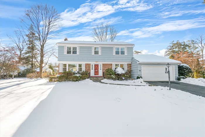 This classic Colonial home features a sunny foyer with a spacious closet and a large living room with overhead lighting and a wood-burning fireplace. The formal dining room opens to a large kitchen equipped with a gas range and plentiful counter space. The family room includes a skylight and sliding glass door that leads to a patio and flat yard. The second floor boasts hardwood floors under the carpets and features a king-size primary bedroom suite with a newly renovated ensuite bathroom and two walk-in closets. Three additional family bedrooms with ample closet space share a hall bathroom. The home also includes a two-car garage, a powder room, Anderson replacement windows, and a basement rec room with a separate laundry room and utility room. Additional features include a new gas hot water heater, hot air heat, central air, and a basement French drain with a sump pump.