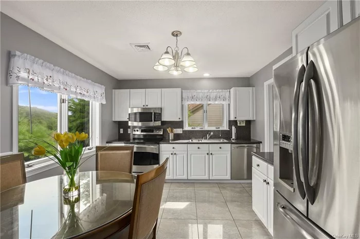 Bright and sunny front kitchen with SS appliances.