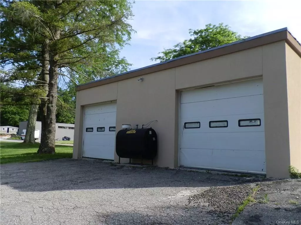 Free Standing Commercial Garage/Storage/Workshop. Great for tradesman to store vehicles and supplies. Two garage bays convenient for loading/unloading materials or just parking your trade vehicle indoors. Office/Storage room in center of garage.