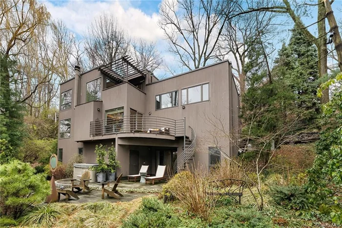 Stunning Unique contemporary home with Hudson River views nestled in the trees at the end of a cul-de-sac for extreme privacy. This home itself is a piece of art with unique features allowing light to stream from all angles at all hours of the day. The double height entry is large and open with a skylight and custom built-ins, plus powder room and oversized coat closet. The large family room on this level has additional custom built-ins for storage and has amazing light with river views.  Leading from the foyer you step into large great room that includes a living room with a wood burning fireplace, custom bookshelves large windows leading to a deck overlooking mature garden and more river views, a dining area room plus a separate semicircular library/sitting room with windows all round. Radiant heat floors as you enter an open modern kitchen, with two sinks, two dishwasher, two ovens, with eat-in area under a stunning skylight, sliding doors to a patio for enjoying your morning coffee in an ultra-private garden with a custom water fall that flows through a garden area, allowing for an amazing sight and wonderful tranquil sounds. The lower level consists of three bedrooms, three full baths, one of the bedroom offers a private suite with walk in closet and semicircular sitting room and private bathroom. This level also has a den/fitness with a full bath with a patio that opens to the garden. There a large laundry room/utility room that completes this level, with an extra storage room for all your needs. The upper level of this home features a gorgeous main bedroom suite with multiple walk-in closets with skylights and extra sink, En-suite bathroom with soaking tub and large shower, and private patio to enjoy incredible views plus a home office. There is an additional room on this level ideal for a nursery or a second home office and has its own private deck overlooking the river. The backyard offers more privacy with views and a hot tub overlooking it all! Conveniently located in close to Metro North, express buses, schools, shopping and restaurants and 20 min drive to midtown Manhattan. This home is truly a rare find in NYC.
