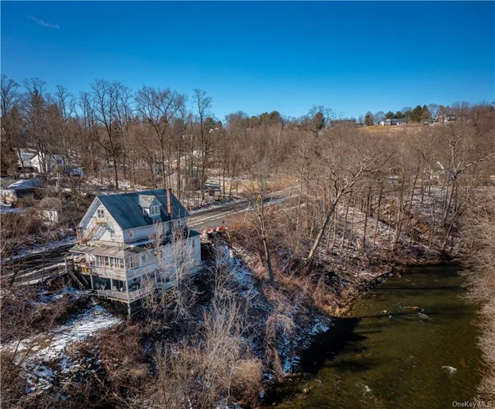 Overlooking a bend in the scenic Ten Mile River. Additional income with 3 rentals upstairs, two 1-bedroom apartments and one 2-bedroom apartment, currently rented month to month.