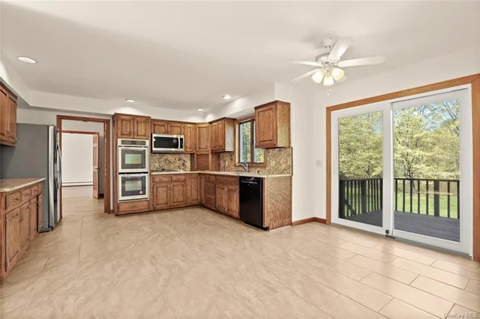 Renovated Kitchen with New Stainless Steel appliances and granite countertops. Breakfast area with Glass doors out to deck.