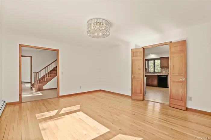 Sun-filled Formal Dining Room with hardwood flooring, and doors to Kitchen and Family Room.