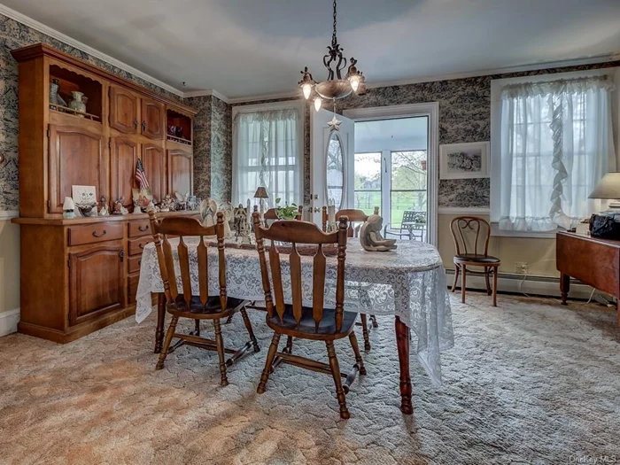 Spacious formal dining room with door to side porch. Hardwood floors underneath carpet, as in most of the downstairs rooms.