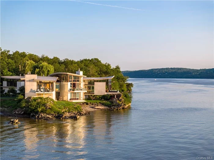 A modern-day tour-de-force, this epic Hudson River showplace shares its remarkable waterfront setting with a guest house, sculpture garden, collector&rsquo;s garage, and 5-star amenities that transcend the ordinary. In the heart of the Hudson Valley, this enchanting estate is one of the few properties to stand directly on the Hudson River&rsquo;s shores. And it rests on a private peninsula embraced by the sparkling river and majestic surroundings. Seemingly floating above the water, the dazzling 5-bedroom residence and its matching 3-bedroom guesthouse take architectural design to a new level. Radiating sophistication, the home&rsquo;s vast glass walls open to expansive terraces over the river while soaring ceilings and rare wood, marble, and stone create an unforgettable backdrop for luxury living. In addition to stunning indoor and outdoor pools, you&rsquo;ll enjoy a gym, theater, fire pit, spa, outdoor kitchen, dock, and a private helipad. Located close to Rhinebeck, New York City is only 2 hours away.