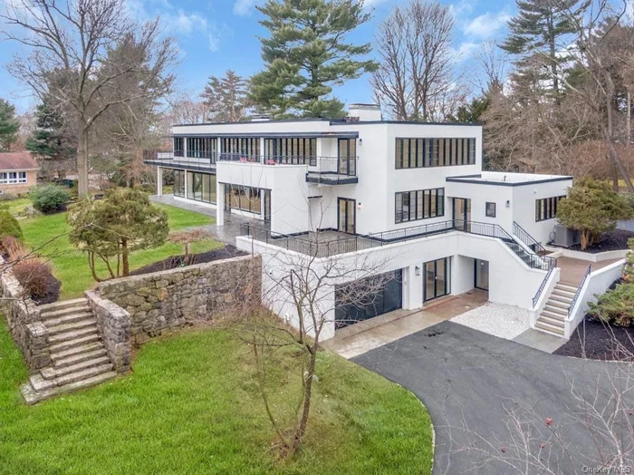 A Bauhaus Is a WOW house. An authentic one is a very rare find. 39 Penny Lane in Scarsdale is the real deal. Designed by Paul M. Doering who studied at the Bauhaus School and built this in 1937 for his parents (the family emigrated from Germany). This home is the definition of Bauhaus form, function and provenance. Bauhaus architecture&rsquo;s characteristics include functional shapes, abstract shapes used sparingly for d cor, simple color schemes, holistic design, and basic industrial materials like concrete, steel, and glass. This period piece which is sited on a gentle rise and commands its own private acre has been thoughtfully preserved and carefully curated with an eye toward modern comforts and utility while holding on to the singular purpose and intrinsic beauty of the original vision. Walls of glass block, clean lines, enormous open spaces, soaring ceilings, steel stair railings and floor to ceiling windows invite a cinematic amount of light that bathes the brand new hand-lain herring-bone oak flooring which is in keeping with the clean linear sight-lines. You&rsquo;ll just want to dance in the absolutely enormous living room which features a wood-burning fireplace (1 of 4), and an original mahogany sliding wall which glides on a brass track to create an intimate dining space. What&rsquo;s new? It&rsquo;s an extensive list (see separate sheet with (improvements) but the highlights include all new Marvin windows & doors which carefully echo the original steel casements, new HVAC system, new copper cladding & flashing, interior and exterior paint, pointing, new roof membrane, new electrical panel, outlets & switches and all new bathrooms with Carrera marble tile work. An all new butler&rsquo;s pantry with one of two Bosch dishwashers kicks off the party as you head into the brand new kitchen with a Bertazzoni induction range, Viking refrigerator and built in microwave and, and, and. What&rsquo;s original & restored? Olive knob door hinges, built-ins everywhere, the lounge, stair rails, fireplaces, exterior stone stairway from the patio to the lower yard, the balconies (with new bluestone surfaces and railings) the lines, the vibe, the inherent cool .. Let&rsquo;s review! 8 Bedrooms, 5, 400 square feet, 1 acre of property, Specimen Plantings, Edgemont Schools, New Comforts & Convenience, 1930&rsquo;s Solidity & Craftwork. All this and it bears repeating Authenticity! Privacy, Property & Provenance on Penny! BE PENNY WISE!