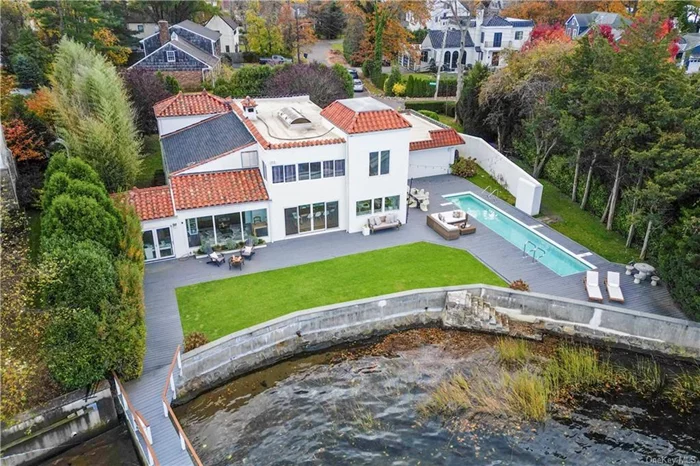 Embrace picturesque waterfront living with this Mediterranean-style gem in Mamaroneck. Boasting breathtaking views from every angle, this prewar beauty offers the ultimate in outdoor recreation with a large deck, deep water dock, and in-ground lap pool. With three bedrooms, three bathrooms, and timeless architectural details, this 3, 078-square-foot residence exudes character and charm. A two-story foyer introduces exquisitely appointed living spaces including the wood-beamed living room with fireplace, sunroom, and dining area all overlooking the serene shore. The expansive eat-in kitchen features floor-to-ceiling windows framing water vistas, while sliding doors provide easy access to your own kayak or boat. A versatile first floor bedroom completes the main level. Upstairs, the primary bedroom and third bedroom both offer ensuite baths and fantastic closet space. Enjoy the tranquil setting and explore expansion possibilities to make this waterfront oasis your own.
