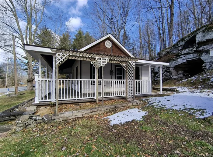 Come see this high efficiency, clean & cozy country home nestled in the hills of Sullivan County. Recent renovations make this 2 bedroom cottage really stand out. Step through the front door from the lovely wrap-around porch or enter through the sparkling kitchen equipped with energy saving appliances. The large stone fireplace in the living room anchors a rustic yet modern motif. The brand new bathroom, water heater, laundry hookups, & powerful ductless heating/AC unit are part of comprehensive updates along with new plumbing, wiring, & insulation. Some of the original hardwood has been rejuvenated while other areas were treated to all new flooring. A third door past the laundry area leads outside to a small shed & the impressive stone outcropping behind the home. To complete the thoughtful updates, a drainage system was installed at the foot of the ample driveway. This modern, efficient gem is waiting for you to fill it with love & make some memories. May also be used as an investment property.