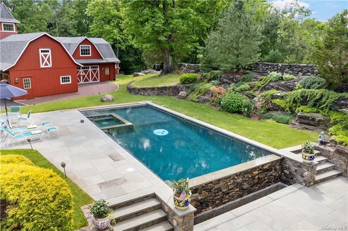 Welcome to a slice of paradise nestled on over 2.3 acres of picturesque grounds conveniently located between the towns of Bedford and Pound Ridge. A stunning gunite pool with a Steelers logo on the bottom of the pool floor beckons you on warm summer days. Surrounded by a meticulously landscaped patio with the pool heated by solar. Unwind in style or host unforgettable gatherings with a top-of-the-line outdoor kitchen, complete with premium appliances and ample seating.The infrastructure to this property is top notch allowing for easy expansion. This unique property offers a harmonious blend of a ranch-style home and a significant barn designed for a car enthusiast with 6 garage doors on the barn plus another two car garage attached to the house. With Wolverine surface in all garages, welding station, car lifts, and a compressed air system and electric car charger. Not a car person, besides the additional 1148 functional sq feet above the barn this structure can be another residence, gym or a series of multiple offices to name just a few opportunities. NEW 4 bedroom septic system and more. Please see the Special Features sheet for more information.