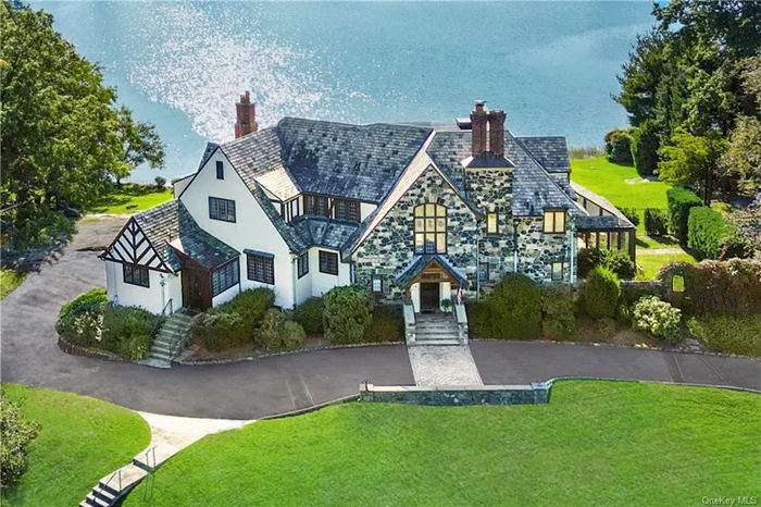 An idyllic location on 1.2 acres, this Tudor style home is set on a private knoll overlooking Premium Mill Pond and the Long Island Sound. It is a timeless masterpiece dating back to its original design in 1924. Architectural splendor graces both interior and exterior spaces, from the intricate details within the home to the private pool and lush grounds. Entering the gracious foyer, you will be drawn to the amazing water view through the double doors leading to the expansive terrace. Both the living and dining rooms resemble and balance one another with warmth and charm and feature fireplaces, window seats and extraordinary water views. At the heart of the home, the sundrenched kitchen, with radiant heated floors, has generous workspace and invites gatherings with access to the terrace through the sliding doors. Adjacent to the kitchen, the family room offers a wooden bookcase and butlers pantry for added entertaining space. To complete the first floor is the guest room with en-suite bath, laundry and mudrooms and a delightful sunroom. The staircase, a masterpiece in the grand entrance foyer, captivates with intricate spindles and has a landing adorned with a stained glass window, leads to the second level. Here, a palatial primary bedroom suite offers mesmerizing water views, built-in closets, a spacious dressing room, and full bathroom. A lengthy hallway introduces two bedrooms sharing a bathroom and a fourth bedroom with an en-suite bathroom. Additionally, a staircase door creates access to the attic and cedar closet. The lower level houses mechanical and storage rooms and an entrance to the garage and gardening room. The waterfront setting beckons opportunities for kayaks and paddle-board adventures or serene moments gazing at the water under the evening stars. The private pool, discreetly located a few steps away, overlooks the water. Take a moment to envision waking up to this water view every day ... the gift that keeps giving!