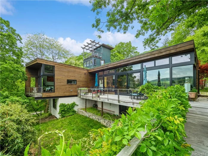 Artisanal, eco-conscious, contemporary compound by architect Larry Wente is situated for an unobstructed view of the Hudson River. A commitment to design and minimal energy use includes employing sustainably grown and harvested teak, local stones and a living deep greenroof. Custom crafted maple cabinets seamlessly integrate into stone surrounds. Skylights and transom windows flood the kitchen with natural light, while the adjacent great room features floor to ceiling windows, merging the interior with the natural beauty of the Hudson River. The first-floor primary bedroom ensuite with floor to ceiling windows facing South & West, provides breathtaking sunsets over the river. A separate guest house is steps from the main house and includes a living room, bedroom ensuite and wrap-around balcony with a view of the Hudson River. Garrison and nearby Cold Spring awash in nature, culture and great restaurants. Access to NYC via the charming station at Manitou or Garrison Metro North.