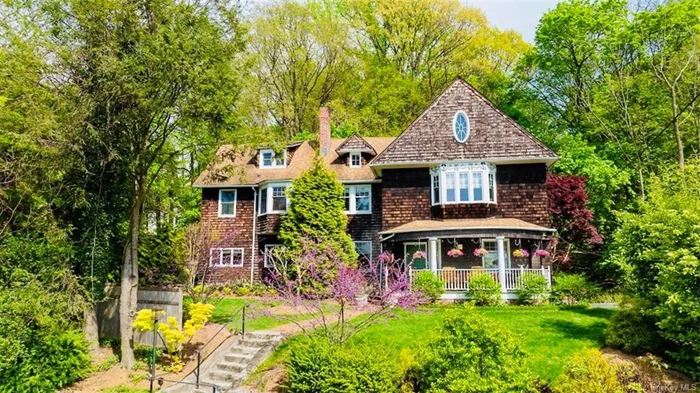 Astonishing sunsets, lush landscaping, stunning architectural detailing, and abundant Hudson River views: this 2023 renovated home has it all! Bordering the Old Croton Aqueduct in the charming Village of Dobbs Ferry, this 2855 sf 4 bedroom /3.5 bath cedar-sided beauty offers elegant living inside - with 9-foot ceilings, glistening wood floors, and 5 wood-burning fireplaces - as well as gracious outdoor living - with private fenced-in side yard and luxurious entry porch. With turn-of-the-century appeal, its charming oval and bay windows with decorative garlands punctuate the fa ade, while the generous front porch gently bows out to provide an ideal location for savoring those fiery evening skies. Inside, delicate glass French doors connect the formal spaces, each with their own distinctive fireplace design. A stately Roman brick mantel in the entry is capped with an exquisite up-lit sculptural frieze. Southern bay windows illuminate the living room. The dining room mantel is a distressed terracotta brick that anchors the room, screening a bright, renovated eat-in kitchen beyond. Here, meal prep is a joy with granite counters, 4- seater peninsula, SubZero refrigerator, Thermador cooktop, tons of storage, and views to the river. The space is adjoined by an ample lounge area for relaxed family gatherings. Proceed outside to the professionally landscaped designed grounds, large stone dining patio, picturesque plantings, and exclusive access to the Aqueduct trail. Scale sunlit stairs to the second floor where all 3 bedrooms enjoy amazing Hudson vistas and greenery views. An expansive primary bedroom features a roomy built-in bay window seat facing the Hudson, as well as a sitting area with fireplace and with a mantel reportedly reclaimed from the Dakota in NYC! Included in the 2023 renovation, the bath offers marble radiant-heated floor and step-in shower, while two walk-in closets complete the suite. As a bonus, a home office off the northern bedroom shimmers with sunlight from a series of expansive picture windows overlooking the yard and river. One level above, discover an enormous 4th bedroom suite (with the home&rsquo;s 5th fireplace and 3rd full bath) with even more amazing views! Ample storage areas are found both here and in the additional 800 sf of newly- finished basement. This pristine home includes a detached garage, new mechanical/ electrical/plumbing systems featuring central AC, 12-zone irrigation system, and Marvin + Andersen windows. With award-winning schools, easy access to 2 vibrant villages, and a mere 40-minute train to NYC, this is truly a rare find.
