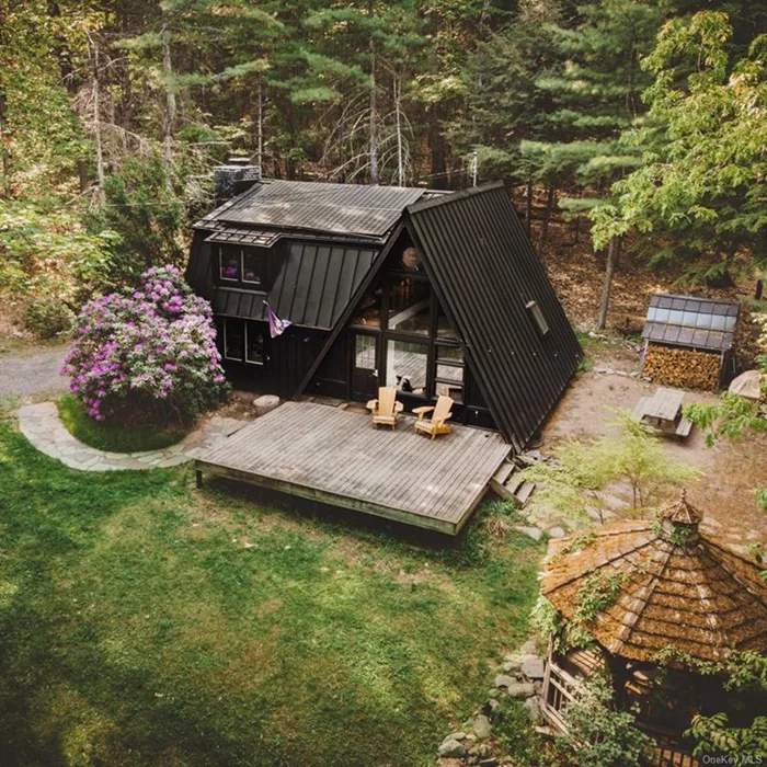 A Black A-Frame is now offered For Sale! Made famous online by it&rsquo;s charm & aesthetic, this renowned property is located in the coveted Town of Kerhonkson, with quick access to many local events & attractions. Minutes to New Paltz or Kingston, and local to abundant hiking trails, lakes, & nature reserves - escape to your own slice of paradise with this stunning year-round retreat! Nestled in nature, this A-frame contemporary home seamlessly blends modern luxury with the tranquility of the great outdoors. Step into the Chef&rsquo;s Kitchen, boasting soapstone counters and high-end appliances, perfect for culinary enthusiasts. Cozy up in the inviting Living Room by the wood-burning fireplace, or entertain in the open Dining Area with a vaulted gathering space. Discover relaxation in two full Bathrooms, each featuring tiled tub/shower combinations, and plenty of space to wash off your adventures. Upstairs enjoy an L-shaped Reading Loft overlooking 2-story vistas while curled up with a good book. Rest easy in two generous Bedrooms with ample closet space, while sleeping under the stars. Outside, find your sanctuary in multiple gathering areas, including a rustic screened Gazebo, a large platform Deck, and quaint Picnic area, all steeped in privacy and seclusion. Mature landscaping with native flowering trees and shrubs abound, and a Spring-fed Pond allows for endless connections. Experience the ultimate escape where nature meets luxury, and book your private showing today!