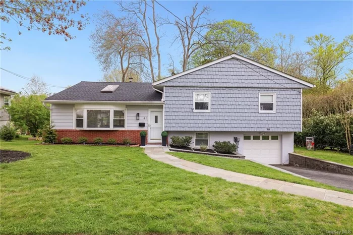 This sunny split level home, located on a quiet street in Hartsdale&rsquo;s Poet&rsquo;s Corner neighborhood makes for easy living. The open concept living room and dining room has cathedral ceilings,  a large picture window, a skylight and access to the patio and yard from the dining room. For casual dining, the kitchen has an island with seating, Corian countertops and updated stainless steel appliances. The second level is only a few steps up and includes two hall bedrooms, a full bathroom and the Primary bedroom along with an en-suite bath. On the lower level is a family room, laundry room with access to the yard and access to the garage. The stone patio is perfect for entertaining and the level yard is spacious. Located within minutes of Hartsdale shops and train, easy access to the parkway and close to the Greenburgh Pool and tennis Courts.