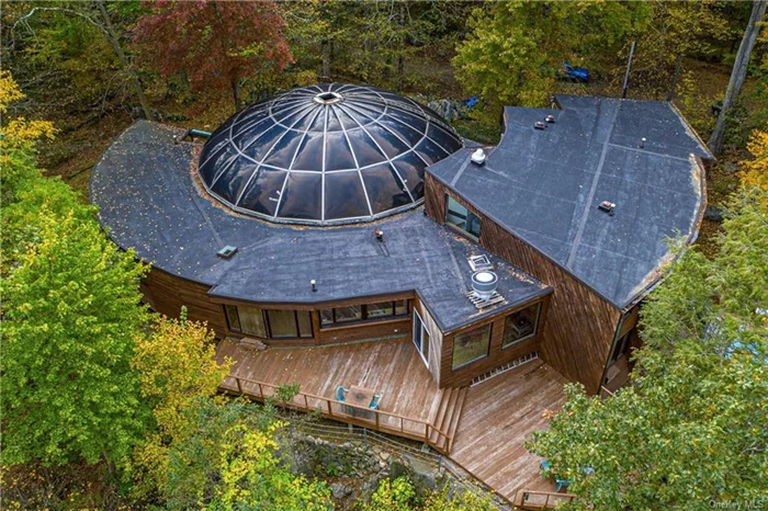 Come experience not only an extraordinarily designed residence, additionally enjoy a home set atop quite possibly one of the highest viewpoints in Chappaqua. Commissioned by the Mechner family in 1969, architect John Koster worked closely with present owners to develop a property like no other. Sited on 8.86 wooded acres with vintage log cabin and sculptural stone outcroppings inspired a multifaceted built home which now offers an incredible opportunity to renew an envisioned masterpiece. An architectural smooth curved arc ceiling immediately excites the senses and draws you into an inviting, flowing living space complimented by a bank of windows arranged to capture the surrounding dynamic landscape. Juxtaposed to this stunning view is a rising wall of glass looking into a one-of-a-kind resplendent domed indoor pool oasis anchoring the home and presenting an exceptionally private retreat. The original open living concept is immediately present with the kitchen, awaiting its reawakening, flowing with ease to a generous gathering room with deck for memorable family and friends indoor-outdoor entertaining. The upstairs of the two-level bedroom wing incorporates a primary bedroom suite with dressing room, its own office and a plumbed bath waiting a new owner&rsquo;s vision. Additionally, there are two bedrooms which share a bath. Stepping into the lower level, with open living space for media and play, smartly complimenting the additional bedrooms and baths. Design. Structure. Nature. Let one&rsquo;s creative spirit soar