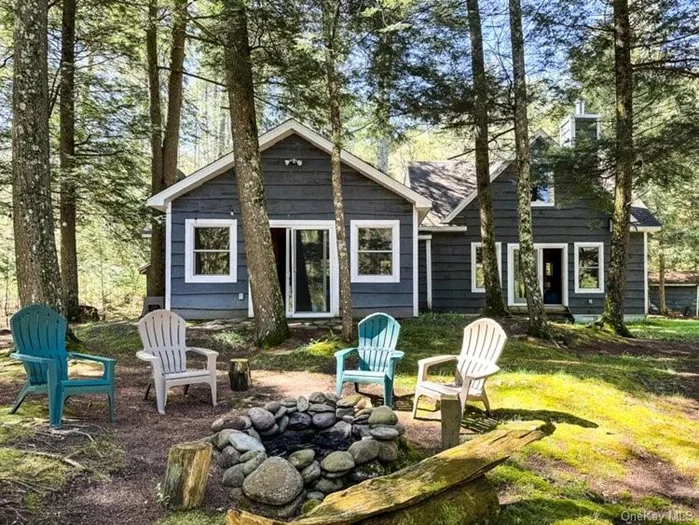 This cabin in the woods was upgraded to a year round dwelling with two large additions: The first a spacious pine-paneled living room with cathedral ceiling, wood stove and glass sliding doors looking out at the woods and Neversink River in the back. Stairs lead up to a generous loft. The other is a light-filled sunken sunroom, with 3 sides wrapped in windows. Another glass slider allows for year round water views. It also provides easy access to the back of the house, where soaring pines with high canopy blanket the ground in needles. It is where owners and their guests gather around a crackling fire, share their stories and are bathed in the calming sounds of the river. The basic country kitchen is roomy and includes a corner for dropping gear, while a staircase leads to a deep loft that could easily serve as a fourth bedroom or office space. A short hallway off the kitchen leads to 2BRs and a bathroom. And then there is the river, whose calming presence can&rsquo;t be over-stated.