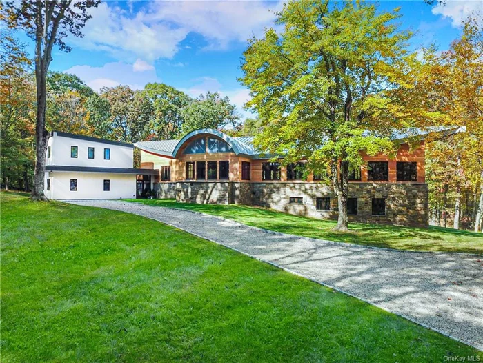 Presenting Col Sheldon, a tranquil haven poised amidst lush woodlands, where architecture intertwines seamlessly with the surrounding landscape. Tucked away on 4 acres within a sought after street in Pound Ridge, this distinctive property showcases a partially completed five-bedroom main house and a fully finished one-bedroom attached apartment, awaiting your personal touches. Drawing inspiration from the iconic designs of Frank Lloyd Wright, the residence features a robust steel structure, yielding expansive interiors accentuated by soaring vaulted ceilings, gracefully arched kitchen and dining room windows, and gently curved walls designed to showcase artwork. Abundant custom floor-to-ceiling windows and doors invite natural light to flood the living spaces, framing captivating views of the ever-changing seasons. The thoughtful layout blurs the boundaries between indoor and outdoor living, merging light, texture, color, and natural elements to evoke a sense of serenity. With the groundwork laid, this home offers the opportunity for you to bring your vision to life and create a personalized retreat that reflects your creative style and preferences.