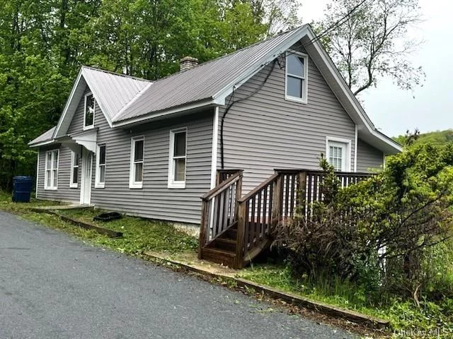 Located in the Minisink Valley School District is this adorable 1-2 Bedroom Home on Quiet Street just minutes to Metro-North Rail to NYC. This property includes additional land which may be sub-dividable with permitted driveway off Feild Street already present. This home features a large kitchen dining area with lovely Deck for outdoor entertaining as well as an enclosed porch/sunroom/Office with great views. There is an additional 368 square foot attic which May be finished for 2 additional rooms or a Master Bedroom. The home alos has a main floor laundry room. This home has a metal roof as does the huge commercial grade Garage with 10 foot floor to ceiling door and an additional car-port. Seller will provide $250 credit at closing for buyer to install railing w/spindles to attic. 2BR assumes the refinishing of at least 1 bedroom up in the attic.