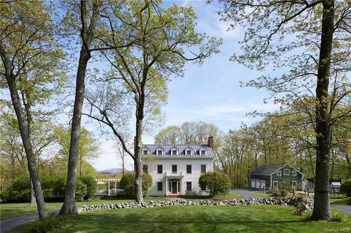 At the end of a drive that meanders through pastures and horse paddocks in the heart of Dutchess County you will find Touchstone, a hidden sanctuary that combines dazzling detail and elegant ease. Touchstone was built with antique architectural components salvaged from a century old home, giving it the feel of history alongside the comfort of modernity. Large windows and French doors invite light and air into every room. There are four fireplaces, a formal dining room with butler&rsquo;s pantry, library, and beautiful living room. The country kitchen with connecting sitting room opens through French doors onto the stone terrace and pool. Beyond the kitchen, a fire-warmed family room accesses a covered porch and lush lawn. The polished wood-topped kitchen island infuses the room with warmth. The primary suite on the second-floor invites pastoral views in three directions. Also on that floor are three more bedrooms and two full bathrooms. Two large additional rooms on the third floor can be used as studios, office space, or playrooms. The third floor has a full bath as well. The pool and terrace have day-long sun and a covered porch provides relaxation and sunset views. A boot room with thoughtfully designed built-in storage and a sink is a touch of inspired convenience when it comes to country living. In the basement, there is a wine cellar and rec room, and above the three car garage a one-bedroom apartment. With open-concept full kitchen and living space, it can accommodate guests from afar. Protected views of Stissing Mountain, gently sloping lawns, and flowering trees and bushes make every outdoor space an opportunity for leisure, play, and pleasure. An architecturally charming bunny house in the raised-bed garden simply accentuates the delight of this property where the living is easy in all seasons. Convenient to Millbrook, Pine Plains, and Rhinebeck, Touchstone offers tranquility just minutes from the best Hudson Valley restaurants, shopping districts, and outdoor opportunities.