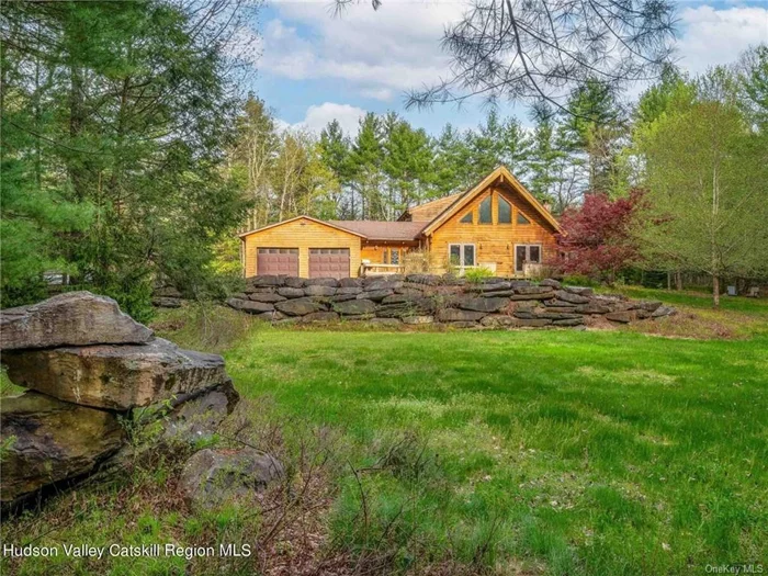 This Alta Log home is set in a beautiful corner of the Catskills close to Woodstock, Phoenicia, Stone Ridge, and the Ashokan Reservoir. At once rustic and refined, it already has everything you would add if you set out to create an idyllic mountain retreat from scratch: a barrel sauna, a plunge pool, a huge finished basement for games and entertainment, a 2-car garage, a garden, a wine cellar, wide open living spaces with soaring, wood-clad ceilings and exposed joinery, clever design touches that make this house just a little bit different from other Alta homes we&rsquo;ve seen, and the birds, bees, and critters you&rsquo;ll love to watch through the many windows that characterize all Alta homes. Set in the center of a 5.65-acre parcel with old-growth hemlock trees surrounding the winding drive to the house, this 3 bedroom, 2.5 bath house was designed for a connection to nature with a deep deck on the front that looks out over the peaceful woodland landscape and accommodates dining, planting, and parties. Inside, the vaulted ceilings of the great room are anchored by the woodstove&rsquo;s hearth (a huge stone taken from the land) and a smart use of color. Off the great room, a large home office has access to a private patio on one wall and the backyard on the opposite side - it has an expansive, creative feel that would be difficult to recreate elsewhere. The first floor is finished off with two bedrooms, a full bathroom, an impressive entry, and a powder room. The second floor is dedicated to a huge master suite that offers privacy and escape. With a window seat that offers on-high views of the land and room for several seating areas, it feels like a cabin in the sky. The suite&rsquo;s bath is gutted and ready for renovation - finish it to your taste to make this escape 100% yours.