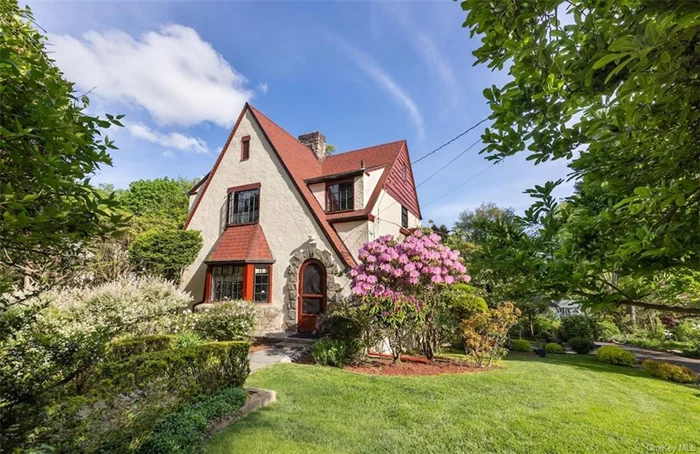 Welcome to 41 Windsor, a country cottage in the Tudor-style, sitting on a lushly landscaped corner property in the serene Shado-Lawn neighborhood of Hastings-on-Hudson. Original architectural details contribute to the home&rsquo;s character, such as an arched stone surround at the entry, leading to a heavy oak front door with an elegant stained-glass panel. Steel windows, a projected bay on a stone base, and hardwood floors with decorative borders all add to its charm. A sun-filled and expansive living room is located off of the stair hall and features a wood-burning fireplace with stone surround, south-facing bay window, and built-in display shelves. An adjacent dining room enjoys two greenery exposures and a convenient pass-through to the kitchen. Wide glass sliders lead to a generous wood deck for outdoor living, lounging, and listening to all manner of gentle birdsong. Eastern light floods the kitchen, which offers stainless steel appliances, granite counters, and plenty of storage/pantry space. A kitchen door leads to the deck and provides immediate stair access to the side yard. Upstairs, a central hallway is filled with light from a large eastern window that illuminates the stairway. Three bedrooms all have wood floors and verdant views, with the primary offering a wall of closets and wall-mounted AC. The walk-out lower level(an extra estimated 250 sf) contains a spacious home office with floor-to-ceiling windows. Amenities include full pull-down attic, ample turn-around driveway, 2017 new roof, 2023 new deck, 2023 water heater, 2022 new electric panel, and a property which offers lawn and garden areas, all with a country calm. For further outdoor enjoyment, discover the 22-acre Burke Estate, accessible by path at the end of the street, as well as the nearby Croton Aqueduct Trail and Lenoir Nature Preserve. With award-winning schools, close to a vibrant downtown, and a mere 40-minute train commute to GCT, this home is a must-see.