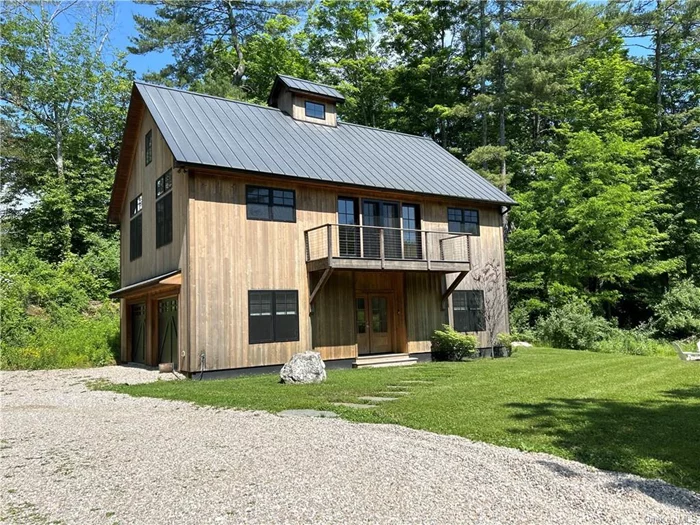 Exceptional Nantucket- style upside-down modern farmhouse in Lakeville, Connecticut, presenting a unique opportunity for those seeking a blend of contemporary architectural design and pastoral tranquility. Designed with many large windows to draw nature in, this property features an elevated living floor plan specifically constructed to maximize the breathtaking views of the surrounding wetlands and wildflower expanses. The house currently offers three expansive bedrooms and an additional designed loft work space, potential for easy fourth bedroom expansion or a convenient attached garage. The interior boasts elegant wood flooring throughout, dramatic ceiling heights that contribute to the sense of openness, a custom staircase design that serves as a focal point within the home, an elegant fireplace centered in the living room, and a stunning balcony off the main living space that overlooks the wetland landscape.