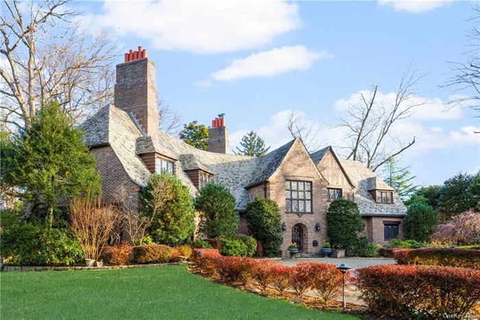 Welcome to 15 Fenimore Road, a 1927 Lewis Bowman Tudor brick and stone home. Step into the grand two-story Entrance Hall with a breathtaking winding staircase, epitomizing timeless elegance. The Living Room exudes historic charm with a large antique fireplace, recessed oak paneling, and random width-pegged oak floors. Sunlit French doors connect it to the year-round conservatory, boasting a wood-burning fireplace and a separate heating and cooling zone. An English-style Library adjacent to the hallway showcases a marble fireplace, arched oak bookcases, and ornate decorative moldings, a haven for book lovers. From the Entry Hall, enter the gracious formal  Dining Room with arched oak French doors leading to a Family Room with terracotta floors. The Kitchen wing includes a butler&rsquo;s pantry, half bath, and laundry room. From the other side of the kitchen, we have a lovely Breakfast Room with terracotta floors with access to the outdoors. Additionally, there is a rear staircase, a large pantry, and a service entrance. Approaching the Second Floor, the sunny landing is framed by a large stained glass window and window seat. The Primary Suite features a bedroom with a fireplace and an intricately designed French-style dressing room, complemented by a Primary Bath. There are two other bedrooms and a bath. The East Wing boasts three bedrooms and two full baths. The lower level includes a large Theater, Exercise Room, and a bathroom with a steam shower. The backyard consists of a blue stone, fish pond, a patio and 2 1/2 car garage with room for a Pool.