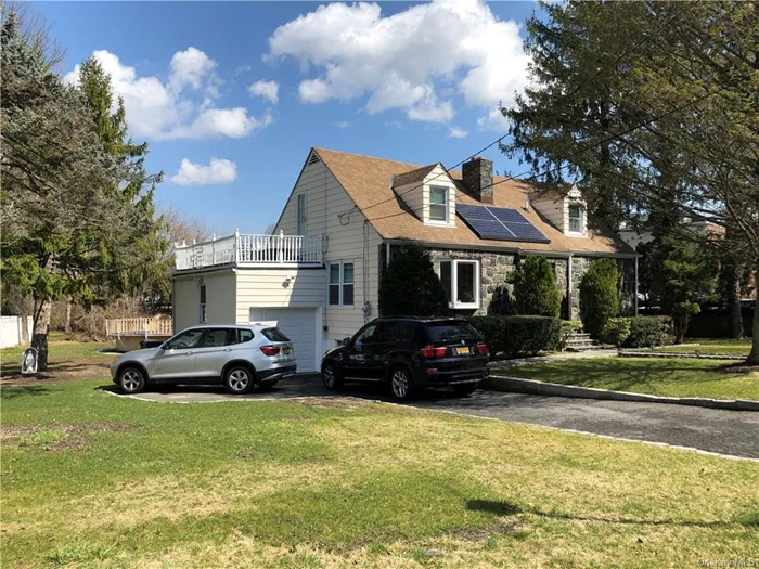 4 Bedrooms plus a Den - 4 Bathrooms. Unique & thoughtfully renovated stone-front Cape Cod. Close to shopping, restaurants, express bus to NYC, a 4 min drive to the train station. Living room has a bay window & a new fireplace surround. New hardwood flooring throughout  first floor. Entertain in this well-appointed home, whether it be by the fireplace in the winter or on the deck on warm summer nights. On the 2nd floor you can sip an iced coffee on the rooftop deck while the solar panels soak up the sun and the sprinkler system keeps your grass green. Enjoy cooking in the sun-drenched kitchen, boasting stainless steel appliances, granite counters, a greenhouse window and door to back deck. The dining room features built-in cabinetry. Main level has 2 BR. 2 more bedrooms upstairs (one has access to the rooftop deck over the garage) and a full bathroom. Finished Walk-out basement with full bathroom 900 sq ft (storage only-not included in total sq. footage) Den with private entrance.