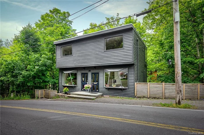 In the heart of Woodstock Village, this light-filled commercial space has it all: easy access from nearby Tinker Street and magnificent views of a stream and waterfall from a treehouse-like setting. Once a gallery, this three-level building currently houses two creative businesses befitting Woodstock&rsquo;s history as a hub for the arts and innovation. A quick step up from street level leads to a modern, two-story, 928-square-foot office space featuring a corner kitchenette, light-colored hardwood floors, unique town-facing windows, a full bath, and a wall of windows overlooking the trees, stream, and waterfall. Beneath the office space, there&rsquo;s a 340-square-foot studio with a half-bath and private entrance accessed by stairs leading down from Tannery Brook Road. This beautiful turnkey property could serve a single purpose or a custom mix. Possibilities include an art studio or gallery, yoga studio, wellness center, therapists&rsquo; offices, engineer&rsquo;s/architect&rsquo;s office, retail business, coworking space, and music studio. (The lower-level studio is currently leased until the end of September at $1600/month plus utilities.) Parking includes a dedicated space out front for one car and access to the municipal lot across the street. Few places in the Village offer town frontage along with inspiring nature views. What could you create here?