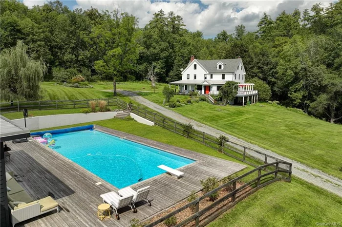 Cutting a handsome profile, this former boarding house has the best of many worlds. Not only do you have 18.8 acres and a babbling brook to enjoy but the convenience of being 3 minutes to Main St of one the cutest towns in the region. Not only do you have over 3000 sq ft in which to spread yourself out, but a heated pool and pool house in which to frolic. It was revived and updated with modern, efficient systems, including Pella windows, foam insulation, an on-demand hot water heating system, and a large porch addition.  The sunken living room features a high-efficiency wood-burning fireplace and a cozy movie watching on a wall-mounted TV. The open-design kitchen is perfect for dinner parties, with four barstools where guests can sit, sip cocktails, and chat. Adjacent to the kitchen, the dining area has sliding doors that lead to the dining porch. A trellis allows wisteria to form natural shade on warm summer days, and a grill stands at the ready. The 7 bedrooms are spread across 3 floors. The primary suite on the 2nd floor has beautiful light and a deep soaking tub, ideal for unwinding after a stressful day lounging by the pool or after a winter hike. Four other BRs line the long hall. The third floor has two. The open area has previously been used as an office but would make a great work/play area. There are two separate basement areas. The unfinished area contains the mechanicals and storage, while the finished basement is a cozy den, perfect for a pool table or movie watching, complete with a fridge and dry bar. A wood stove keeps this area warm in winter. The pool area is an ideal summer retreat, with a large deck around the 1, 000sq ft pool. The pool house serves as a playroom for all ages. The house benefits from the soothing sounds of a year-round stream just below, creating your own oasis of calm. The dead-end road sees next-to-zero cars passing by.