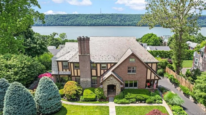 Year round Hudson River views and endless sunsets over the Palisades! Step into the epitome of refined living at this stunning 1923 Tudor home nestled within the serene riverside community of Woodstock Manor in NW Yonkers. This residence is impeccably maintained with meticulously landscaped gardens, and boasts original charm with 5 Bedrooms, an expansive Kitchen that invites culinary creativity, Formal Dining Room, Living Room with original limestone fireplace, Library, heated Sunroom and original hardwood floors throughout. Ascend the grand central staircase revealing the hidden treasures of the bedroom level. Back stairs to the third-floor reveal the unfinished attic offering boundless possibilities. The lower level serves as a versatile retreat, with Multi Purpose/Home Office, Family Room with Beverage Bar, Spacious Bedroom and Half Bath opens out to a charming stone patio and verdant garden oasis. Graceful architecture, lush surroundings and amenities, this residence offers a lifestyle of unparalleled sophistication. Make this dream home yours today.