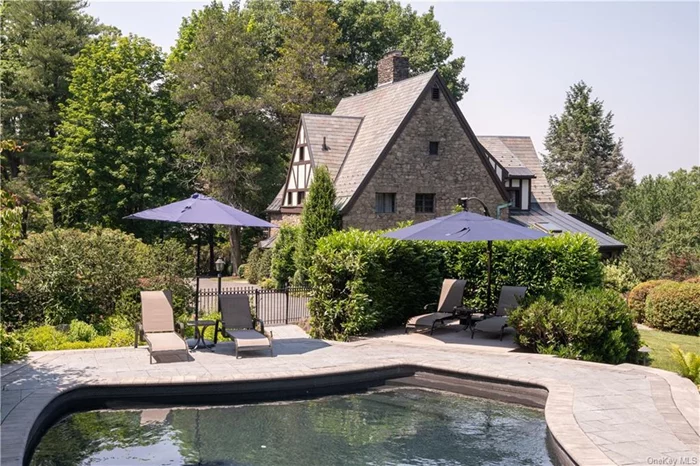 A truly rare Tudor Revival mini-estate with unbounded views: a panorama of blue-gray Hudson River with the Westchester hills in the distance and the little town of Nyack below such is the description of this magical property which in 1926 was part of the first American Ashram inspired by yogi and spiritual leader Pierre Bernard of the great Oom. This 4 bedroom, 4.5 bath stucco and stone home is a work of craftsmanship with steeply pitched roofs, multiple gables and half timbering that features rustic stone porches and hand crafted artistry both inside and out. It will delight your whimsy and love of history but it is also firmly grounded in the 21st Century with a custom chef&rsquo;s kitchen, updated baths, two laundries, state of the art heating, cooling and landscaping which features specimen trees, patios and terraces with pristine perennial gardens offering color and texture to all four seasons, framing the expansive hudson valley views from every angle of this 1.1 acre oasis. A restored Gunite salt water pool is a serene punctuation to the astounding beauty of the grounds. Inside the rooms are spacious and magical -many featuring river views, beautifully figured maple arched doorways, Pecky Cypress 9ft. ceilings, pine and local bluestone floors. Two-car stone garage, deer fencing, restored steel casement windows and custom wrought iron gates are just a few of the serious features of this lovingly restored home bordering state property and perched high on the hills of south Nyack.