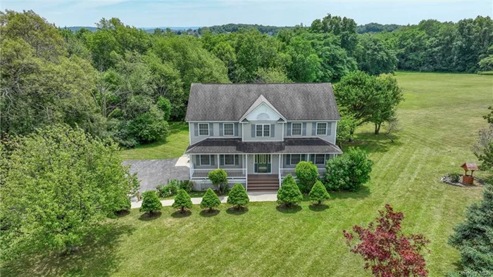 This meticulously maintained four-bedroom Colonial-style house is situated in the desirable Minisink Valley School District. Set on 5.8 acres, the property features an inviting front porch and a large back deck accessible from the kitchen. The first floor includes a grand entrance foyer, an eat-in kitchen, dining room, living room, family room, laundry room, and a half bathroom. The second floor houses four bedrooms, featuring a primary suite with a cathedral ceiling, recessed lighting, a full bathroom, and a spacious closet. The other three bedrooms are well-proportioned, sharing another full bathroom on the same level. Pull-down stairs allow for convenient attic entry. The basement offers a perfect space for a media room or guest area, equipped with a third full bathroom. The extensive backyard, friendly for pets, is ideal for summer activities, offering ample space for picnics, barbecues, volleyball, or wiffle ball. Located within easy commuting distance to New York City, this home offers a blend of country charm and privacy. Nearby attractions include Legoland, Bethel Woods, Resorts World Casino, Kartrite Water Park, West Point, Stewart International Airport, and the Delaware River.