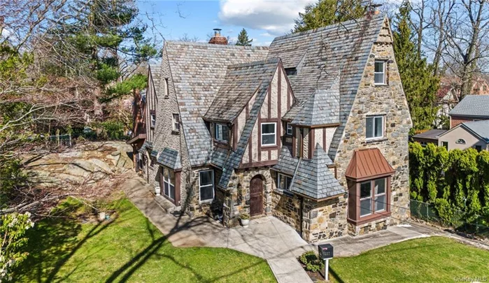 Tudor home loaded with sophistication & style. This large house has original details throughout that have been carefully preserved, including arched doorways, a curved staircase, rich hardwood floors, stone fireplaces, and custom woodwork. On the first floor there is a gracious foyer, showing off the arches and staircase, sunk in living room, formal dining room, and kitchen and 3 season room attached, powder room, and small bedroom Upstairs there are four generously sized bedrooms, primary bedroom has en-suite bathroom. Full finished attic, a versatile space ideal for use as a home office, playroom, or any additional space your heart desires. Fully finished basement provides with high ceilings and a fireplace. 2 car garage built in garage, seamlessly integrated into the home.All this surrounded by mature landscaping, serene neighborhood, leafy green surroundings.