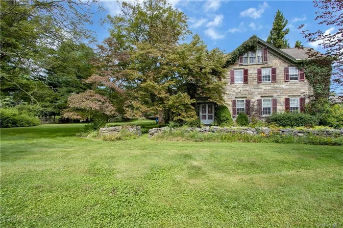 This historic stone home is an extraordinary blend of timeless elegance & modern convenience. Every detail is designed to inspire and delight.  Built in 1791 by Jacob Mills, it was occupied by his descendants until the 1980s   The Manor invites you into the foyer through the breezeway. Pause as you enter the kitchen and take in the vaulted ceilings and shaker-style cabinets. Follow the open concept into the family room.  The craftsmanship in all rooms is unmatched, highlighted by features like pocket doors that blend spaces seamlessly, built-ins that add functional charm, and window paneling that frames picturesque views of the lush surroundings. The main bedroom, bathed in light, provides a peaceful escape. All bedrooms are generously sized & offer plenty of storage.  The screened flagstone porch is perfect for enjoying your morning coffee. The beautifully maintained gardens surrounding the in-ground pool create a picturesque backdrop for summer gatherings.