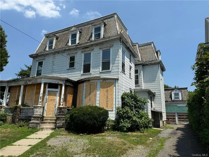 Large 3 family house with a detached 2 car garage and basement on a corner lot. This home has suffered fire damage and all utilities are off.  Repairs are significant but well worth the effort to restore this grand property to its original glory. Many original features and detail remain.