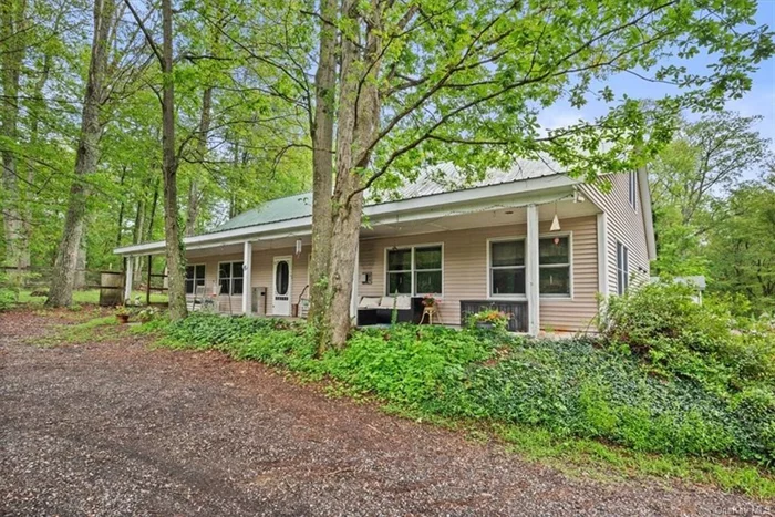 Privacy Abound - Welcome to Your Hidden Oasis  Tucked away on over 13 acres, this one-of-a-kind custom-built home in Pine Bush School District envelops you in peace and tranquility. Step onto the expansive 60-foot covered rocking chair porch and enter through a grand entrance that opens to a stunning floor plan. The open concept design features cathedral ceilings adorned with knotty pine in a natural finish.  The primary suite offers a picturesque lake view and includes a spacious walk-in closet with pocket doors and a cedar ceiling. The ensuite bath features twin shower heads and a luxurious single-person hot tub. The back wing of the home houses three additional bedrooms and a large bathroom with a soaking tub. This wing also provides access to a private deck via sliding glass doors.  The large kitchen is a chef&rsquo;s dream, boasting two stoves, a double-height island, and ample storage. It leads to a loft area upstairs, which includes three generously finished spaces, perfect for additional bedrooms or an office. A full bath with a shower stall is conveniently located at the top of the stairs.  Radiant floor heating is installed throughout the main floor, with ductless splits providing additional climate control one unit upstairs and two on the main floor. Whether you are entertaining guests or simply relaxing with family, the possibilities are endless in this serene retreat. Listen to the sounds of nature and unwind in your private oasis.  Only 74 miles to NYC, 16 miles to Casino and 25 miles to Bethal.