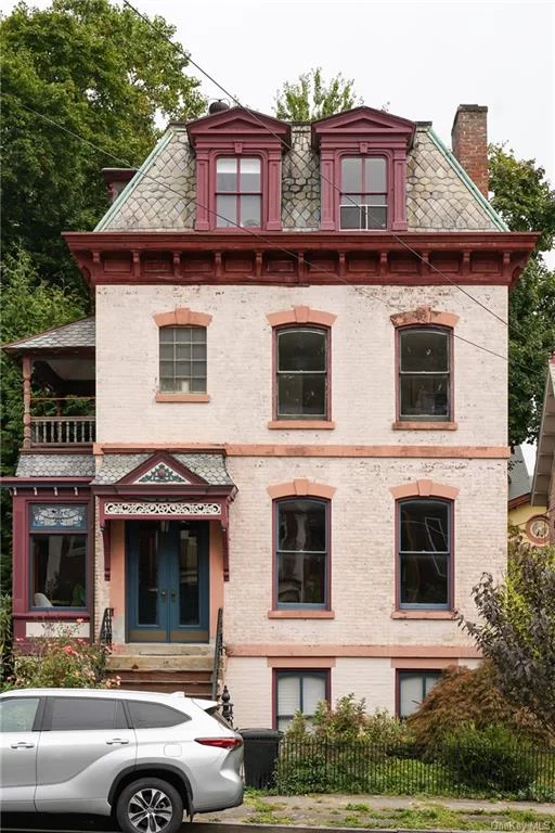 The gem of Liberty St in on the market! Newly updated, this property offers modern comforts amid stunning historical details. Unique historical stairs bring you to the parlor level, which features a large foyer, a living room leading to a dining room, a modern kitchen, a stylish powder room, and a bonus solarium (currently used as a coffee-and-plants haven!). This entire first level is heated with radiant floors under historical hardwood  cozy and easy on the eyes! Upstairs on the second level you&rsquo;ll find three bedrooms, one with bonus office/flex space, and a full bathroom. This level also has a street facing lookout deck and an exit to the back garden via a secret stair that brings the old house charms. On the top level, there are two more bedrooms, one with an ensuite full bath and pretty rooftop views. As the icing on the this pink Victorian home cake, there is a basement with private entrances at the front and back of the home that is perfect as-is for a workshop or creative studio and laundry. It has been prepared by the current owners to be renovated into a separate unit or additional living space. Outside, you&rsquo;ll notice beautiful restored woodwork and details, great neighboring properties, a landscaped yard with mature ornamental trees, and spacious parking spots. This home has so many charming, flexible, and beautiful spaces  perfect for envisioning live, work, and play in the City of Newburgh.