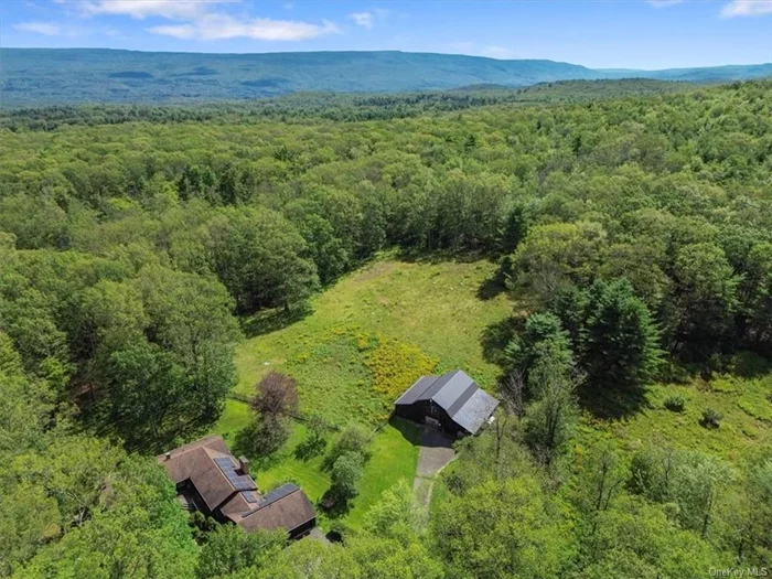 Nestled on a quiet, dead-end road, 119 Mt Laurel makes the perfect countryside retreat.  This 1970&rsquo;s spacious ranch style home comes complete with 2 separate parcels of land totaling 5.8 acres, and a 7 stable horse barn with hay loft and access to a fenced in paddock. Throughout the inside of this expansive home, you will find 4 bedrooms and 3 bathrooms, in addition to two separate living areas with a full kitchen in each, creating the perfect co-living environment. Just off the generous three car garage is a bright breezeway that brings you into the first living area of the home. Enter through the galley kitchen with a generously sized great room with vaulted ceilings and a wood burning fireplace and lots of natural light from the outdoors. As you walk down the hallway with great storage closets, you will be brought to two bedrooms, one an en-suite and the first full bath. A spacious laundry room separates the two living areas in the house and has its own outdoor access. The second living area is smaller, but has a similar concept with the high ceilings and open area and includes two bedrooms and one full bath.  The wrap around deck allows you to enjoy the seclusion of the mountains from all areas of the property. Solar panels (owned) assure low or no electric bills!  Just a 10 minute drive from Kerhonkson, and super close to hiking in the Sundown National Forest and Vernooy Kill Falls. A short drive to local breweries and restaurants such as Arrowwood Farms, Westwind Orchard and Inness Resort.