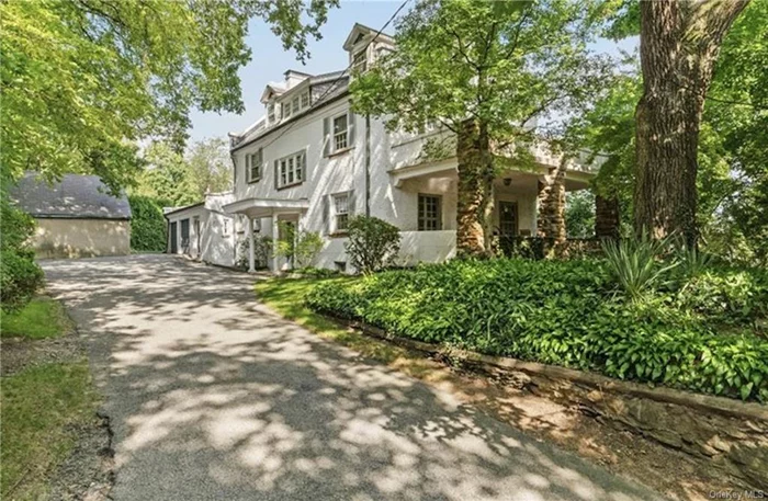 Watch the sunrise above the entire northeast Bronx from your manor house perched atop Spuyten Duyvil hill. This handsome, historic gem features the character and elegance of a bygone era. Designed by noted architect Robert Waterman Gardner, a student of Calvert Vaux and an archaeologist, your new home&rsquo;s architectural details and traditional center-hall colonial elements combine for a uniquely generous living space. Step into grandeur with gracious entertaining spaces including a large entry foyer flanked by generously-sized living room with fireplace and a dining room with quality terra cotta tile floor, oversized windows, and built-in corner cabinets. Classic French doors open to the brick porch, with its stone walls and pillars, leading to gardens and a play area. The remodeled eat-in kitchen with maple cabinetry and stunning granite counters is perfect for event preparation, and quiet conversations over a cup of tea. Upstairs, a master BR suite offers distant city views, a private bathroom, walk-in closet, and French doors opening to a masonry deck. The adjacent bedroom is perfect for a nursery or office. Two additional bedrooms on this level feature oversized windows and garden and/or city views. The third level hosts three additional bedrooms, one very large with windows facing three directions and two half that size each, and a bathroom with shower off the center hall, benefitting from the stunning eastern vista. One of the earlier residences in Spuyten Duyvil, this location is among the most prominent elevations in NYC. Awesome views east. Cool breezes come from the Hudson River one half mile to the west. Your new driveway and garage, with on-site parking for several cars, is a rarity in NYC! Commuter links within a five minute walk include Manhattan Express busses, the number 10 bus, and the Rail Link bus to the Spuyten Duyvil Metro North station. This homesite combines urban convenience and suburban tranquility within a quiet, historic neighborhood. The house is so unique, it has had only three owners since 1910. Schedule your private tour today to experience the timeless elegance of this unique offering.