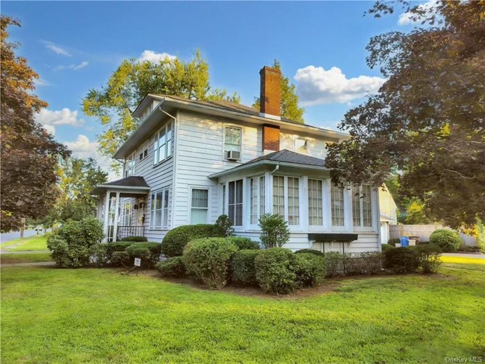 This elegant residence showcases a blend of classic charm and thoughtful preservation, evident from the well-maintained exterior to the beautifully appointed interiors. The house features a traditional two-story structure painted in a soft white, complemented by shutters and framing that accentuate its historic character. The spacious living room boasts a richly textured wallpaper and a brick fireplace, creating a warm, inviting atmosphere. Large, sunlit windows enhance the airy feel, making the space ideal for both relaxation and entertaining. The kitchen is equipped with vintage cabinetry that leads to a cozy dining area, complete with a traditional chandelier and ample natural light. A formal dining room adjacent to the kitchen offers another layer of sophistication, highlighted by its patterned wallpaper and large windows that provide views of the surrounding greenery. Each bedroom is uniquely styled, featuring distinct wallpaper and large windows that draw in sunlight, enhancing the home&rsquo;s welcoming feel. The property includes a detached garage, adding practicality to its charm, and is framed by mature trees and manicured lawns, emphasizing its curb appeal and providing a serene outdoor space. This home successfully combines historical elegance and custom built ins, making it a perfect choice for those seeking a distinctive and well-cared-for residence in Kingston.