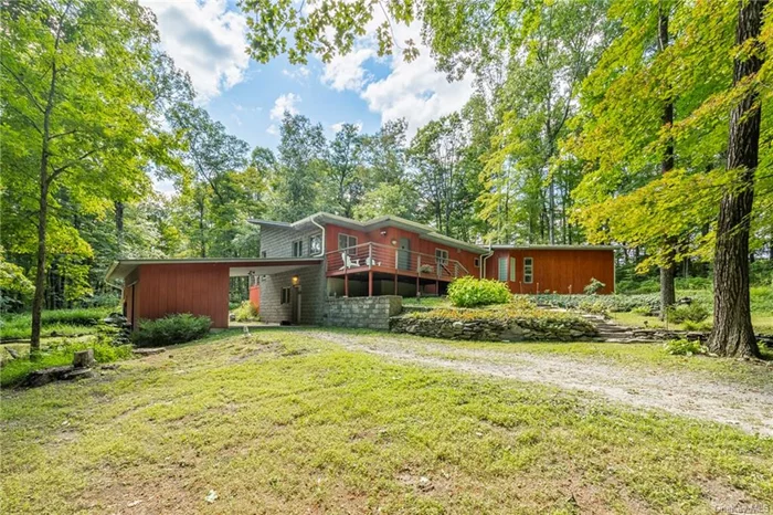 Nestled within a clearing in the woodlands among the ferns is this mid-century modern inspired contemporary home with unique roof lines. Perfectly positioned on the 23.67 acres to embrace the privacy and tranquility of the property, the home features multiple mahogany decks, terraces, carport, perennial gardens and a beautifully landscaped yard. A spacious light filled great room has soaring ceilings, large windows, sliding glass doors to the deck and a wood burning stove. The great room includes a spacious kitchen with center island. A hallway, with full bath, leads to a sitting area and the primary suite which features 10&rsquo; ceiling, two walk-in closet and primary bath with soaking tub, walk-in shower, skylight and water closet. The second en-suite bedroom has doors to a deck. This unique home is truly the perfect, private country retreat. Just minutes to the quaint Village of Millerton.