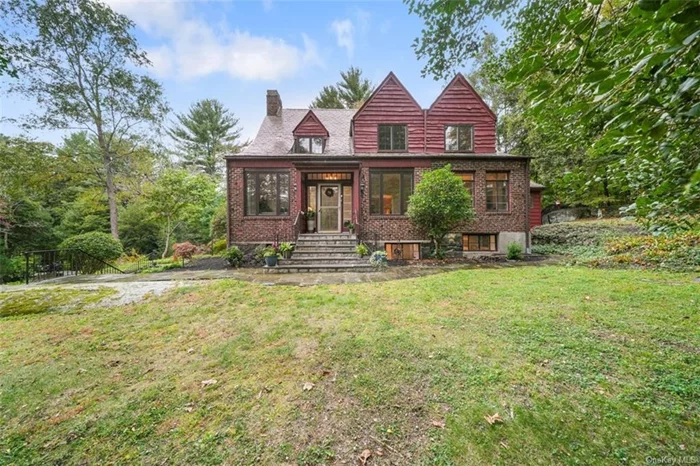 Bucolic setting surrounds this Cotswold-style Tudor which boasts magnificent architectural details including the original banisters, arched doorways, high ceilings with beams, crown molding, built-ins, wide-board pegged floor in the living room and hardwood floors. The sun-drenched interior includes a living room with a wood-burning fireplace, a formal dining room, a sitting room, an updated kitchen with granite countertops and new stainless-steel LG appliances, a breakfast room with vaulted ceiling, skylights and walls of windows and an updated powder room on the main level. There is a primary bedroom with a fireplace along with two bedrooms and a full bathroom on the upper level. The owners designed a playroom, office, and full bathroom on the lower level. There is plenty of storage. Recent updates include freshly painted interior, refinished hardwood floors, central air conditioning, many new windows, new above-ground oil tank, new hot water tank and recent furnace (5-6 years), new washer and dryer. Special features include, high/beamed ceilings, built-ins, arched doorways, two fireplaces, hardwood and wide-board/pegged floors. Stroll through the brick pathways to explore the many gardens throughout the property. A one-bedroom cottage with screened porch, Har-Tru tennis court, pond, a detached garage and two additional outbuildings complete this unique property. It is a short drive to beautiful parks, shopping, the highway and the Croton Harmon Metro-North train station offering trains under an hour to Manhattan. This is a truly special property.