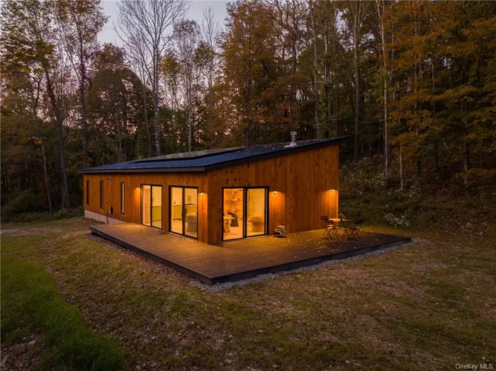 Design-forward with an essentialist theme, Hillcrest House is the latest project of award-winning Design/Build agency, Edifice Upstate, and is fully powered by solar. The house is powered by sixteen sleek, all black modules powering a robust Solark Inverter that provides clean resilient electricity without relying on the power grid. Warm tones and clean lines dazzle in the sunlight. The open plan living space is anchored by the wood stove, designed to heat the whole home, and flows from living room to dining room to kitchen. The full kitchen is designed to be steps from the expansive sundeck and a brief hallways leads to three bedrooms, a full bathroom with walk-in shower, a half bath and extra storage/pantry space. The utility room houses the solar battery bank, water heater, electric panel and pressure tank. No attic, no basement, no maintenance hassle. 100 miles from NYC and walkable to the charming upstate hamlet of North Branch.