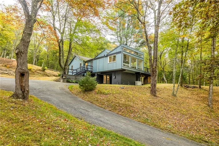 Welcome to The Treehouse, a contemporary home hidden amongst the trees on 9 acres and overlooking a tranquil swimming pond and dock. As you drive up the winding driveway, you are met with clerestory windows and a dramatic sawtooth roof, which was designed in 1973 by Richard Stein, making this a truly unique home. The living room has a woodburning fireplace framed on all sides by floor to ceiling windows bringing all nature has to offer into the home. For ambiance, this house features a Lutron Graphic Eye lighting center with 8 controllable dimmers inside and the forest outside the home lights up beautifully in the night. From the living room, it is seamless for entertaining outdoors through the double sliding doors to a spacious 24&rsquo; x 20&rsquo; deck. There is an additional large back deck with outdoor shower and plenty of privacy. Open from the living room, the kitchen&rsquo;s design adds to entertaining with Bosch dishwasher, Wolf Stove and two Velux Skylights with auto rain sensing technology. Three beds and two baths are artfully arranged, the primary bedroom has a gas fireplace and an ensuite bath with a beautiful glass tiled walk-in shower and radiant heat. The second bedroom also has an ensuite bath with shower. One can also access the many trails on the nine acres of woods behind the home. Covered parking is provided in a breezeway accessible from the basement. Adding to the amenities is an automatic generator, Nest, and A/C. NYC is just 75 miles away, the Metro North trains are an easy 10-15 minute drive and the quaint village of Millbrook, with all it&rsquo;s great restaurants and shopping, is 15 minutes.