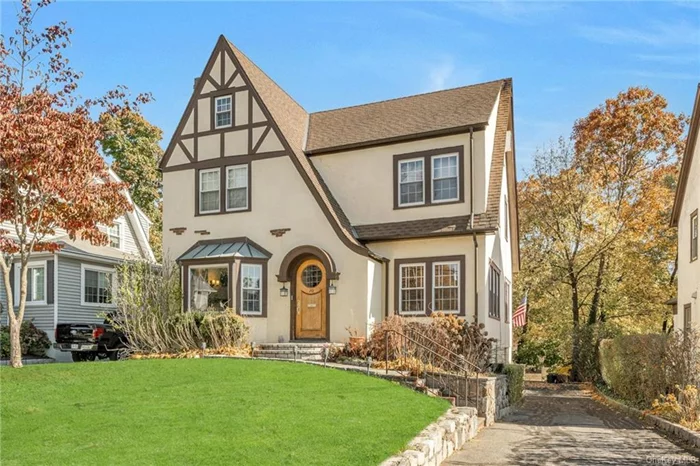 Discover timeless charm in this Storybook Tudor, featuring 4 bedrooms and 2 bathrooms, offering both comfort and character. Step into the inviting living room, complete with a wood-burning fireplace and a wall of built-in bookcases perfect for book lovers. A bright and versatile sunroom doubles as an ideal home office, while French doors open into a dining room filled with natural light. The cheerful kitchen leads to a spacious deck and steps down to a private patio with a relaxing hot tub. Upstairs, find three generously sized bedrooms and a full bath, while the third floor offers a bedroom, full bath, and ample storage. The finished basement includes a soundproof room, ideal for the family musician, and a Sonos sound system for an immersive audio experience. This home blends classic style with modern conveniences, perfect for comfortable living and entertaining. Come make this dream storybook tutor your new home!