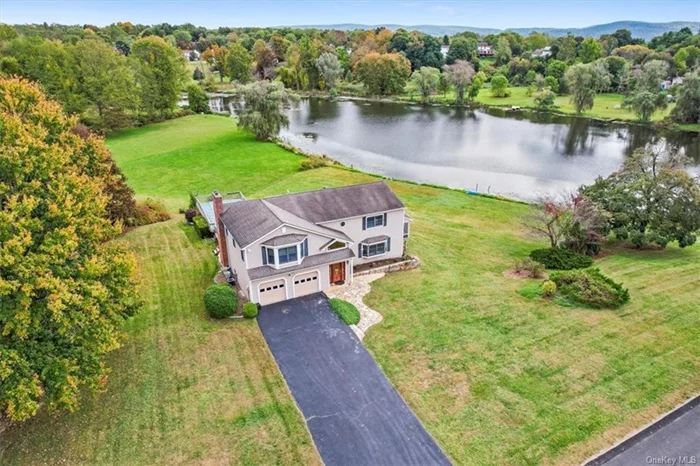 Experience breathtaking lake views year-round with opportunities for fishing, boating, and ice skating. This stunning home, filled with natural light, offers a spacious eat-in kitchen complete with granite countertops, stainless steel appliances, and a cast iron sink. French doors lead to a generously sized family room with a brick fireplace. The formal living and dining rooms feature hardwood floors with walnut inlay and crown molding. The primary bedroom boasts a vaulted ceiling, accompanied by three additional bedrooms and a large bonus room. Enjoy the three-season room with sliders leading to a vast deck and a 20x40 pool with a new liner. Beautifully landscaped property, irrigation system, sun shades, and much more.