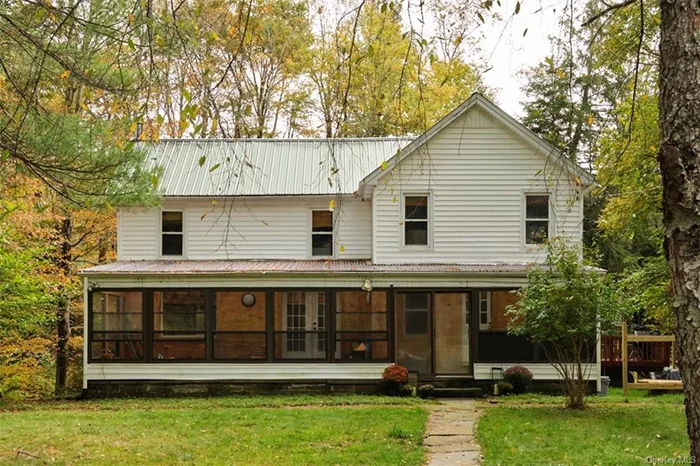 Set less than a mile from the buzzing business district of Livingston Manor, Brookside is a compelling marriage of character and convenience. The gracious good looks of an early 20th century farmhouse, paired with the coziness of a woodsy cabin make this home a crowdpleaser for anyone looking for something a little country. Set back from the road on a picturesque one-acre parcel, with Cattail brook&rsquo;s ever-present hush the primary soundtrack, Brookside beautifully balances the privacy of a country house with the convenience of a house in town.  Entering through a dramatic three season sun room, a proper entryway with storage closets sets the tone. Rich, warm and cozy is the vibe of the day and it is pervasive throughout the home. A large eat-in kitchen with picture window overlooking the side yard is a wonderful place for a morning coffee, or turn on your propane fireplace and cozy up in the wood-clad living room. The living room offers direct access to both the sun room as well as a sun deck overlooking the brook below. One full bathroom as well as a sunny office space complete the ground floor. You could always expand the bedroom count to six by utilizing the office downstairs as a small bedroom if capacity is a priority! Upstairs there are five more bedrooms. All can fit at least a full bed, and the largest two could support King mattresses if so desired. Currently, one of the bedrooms is in use as a walk in closet - a worthy way to utilize all the space this house provides! There is a shared full bathroom upstairs with clawfoot tub, and character to spare. The partially finished basement offers a large and flexible bonus space currently set up as a gym. An art studio, media room, play room, or pretty much anything you can think up would all be great uses of this space.  Outside, an expansive and level yard surround the home with mature evergreens, and fruit trees. A new fence is mostly in place for a dog run or garden. Plenty of room to roam but not too much to maintain - like most things with this home, a welcome balance. Brookside would make a wonderful full time or part-time home with plenty of room to host. With its high bedroom count and access to Livingston Manor it is also an intriguing investment property. Upward Brewery is a couple minute walk, with Main St. proper just a few minutes further down the road. Enjoy the best of town and country at Brookside. Reach out and schedule your showing!